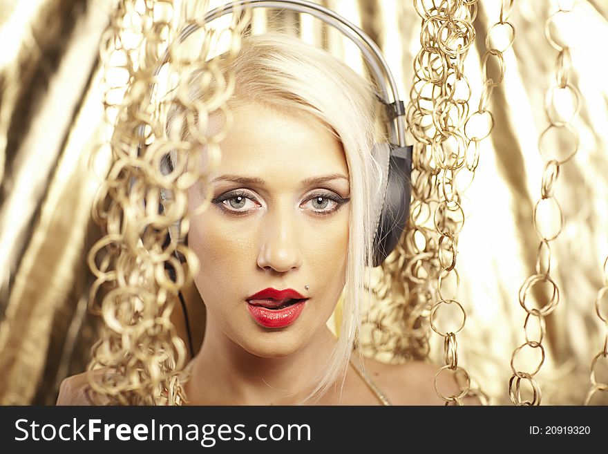 Portrait of a blonde, with red lips and headphones on a gold background. Portrait of a blonde, with red lips and headphones on a gold background.