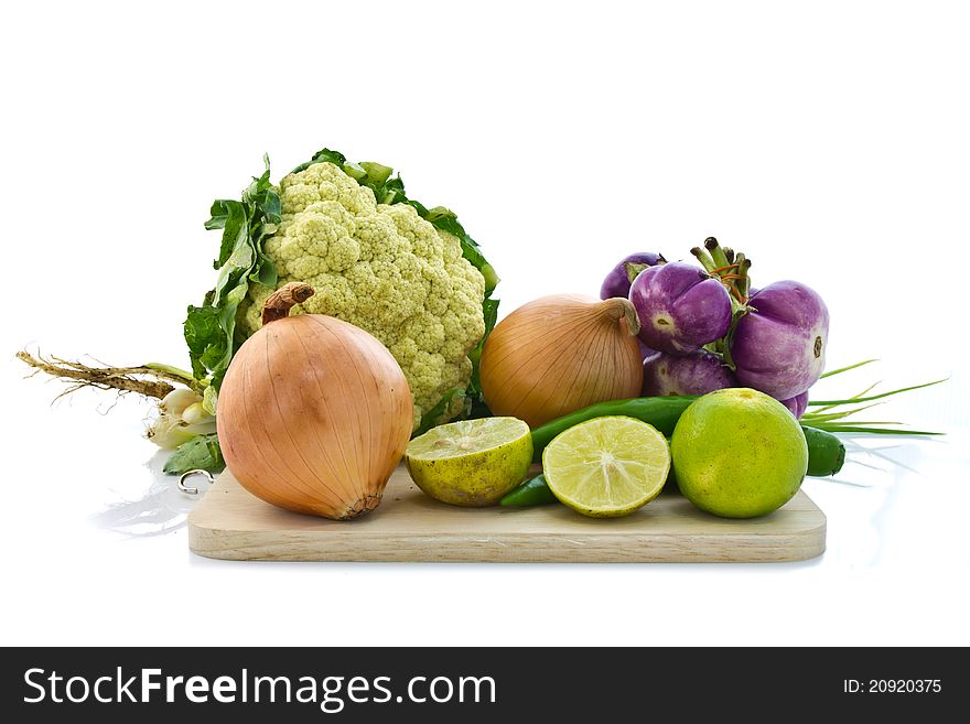 Various kinds of vegetable on chopping board isolated on white