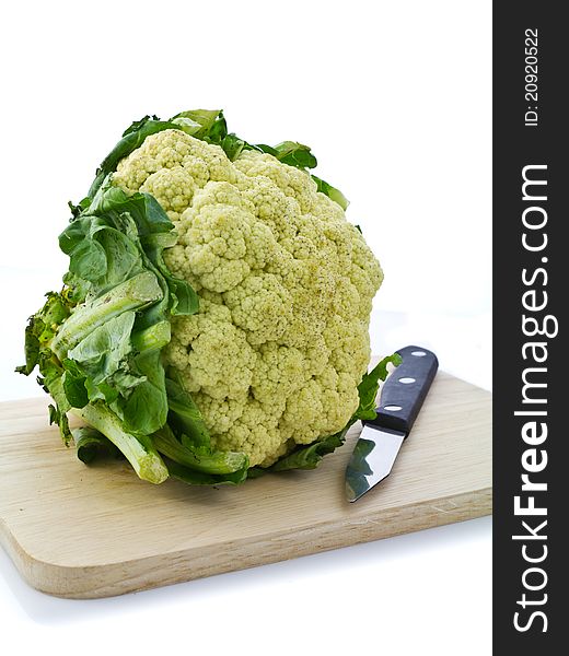 Cauliflower and knife on chopping board