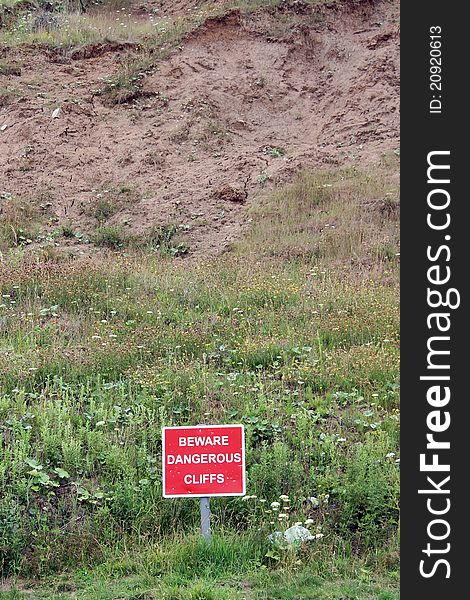 Red Danger Sign beware dangerous cliffs closeup