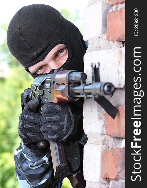 Armed Soldier In Black Mask Targeting With A Gun