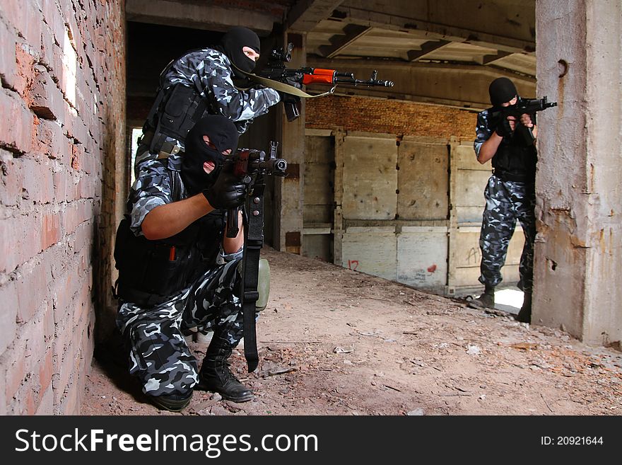 Soldiers in black masks targeting with guns