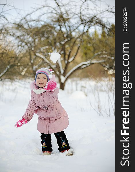 An image of a little girl playing snowballs