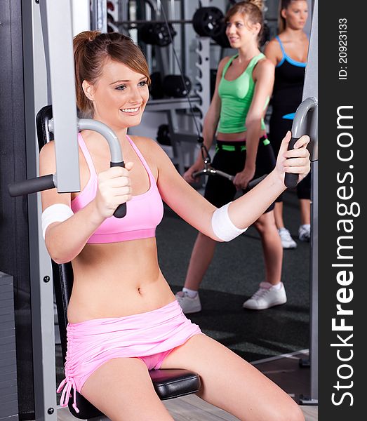 Portrait of young female exercising in gym...