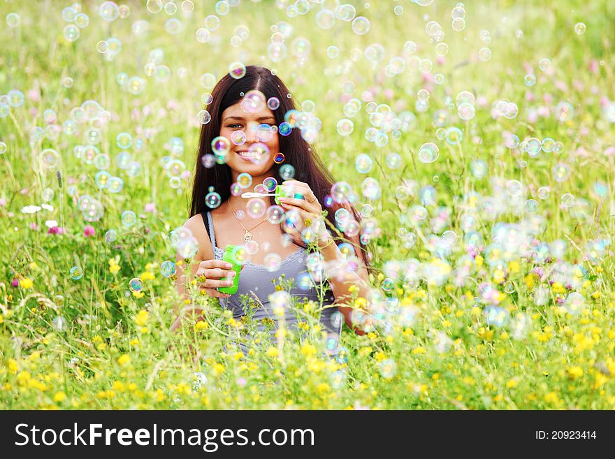 Happy woman smile in green grass soap bubbles around. Happy woman smile in green grass soap bubbles around
