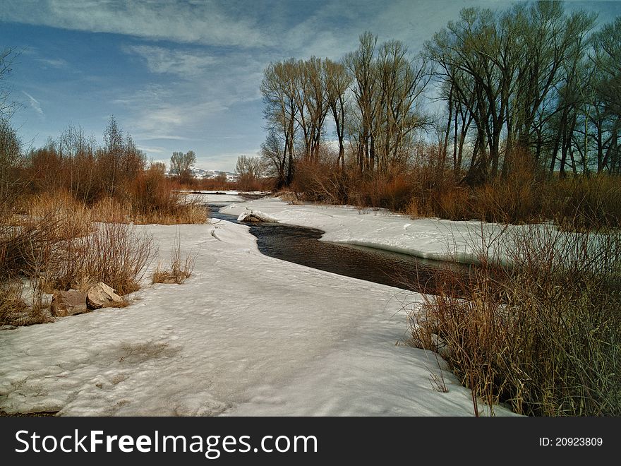 A frozen spring starts melting in early spring. Located in Colorado. A frozen spring starts melting in early spring. Located in Colorado