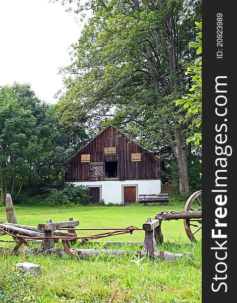 A ancient sled in front of a old barn. A ancient sled in front of a old barn