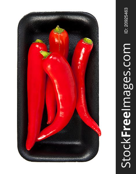 Fresh red hot pepper with black plate on a white background. Fresh red hot pepper with black plate on a white background
