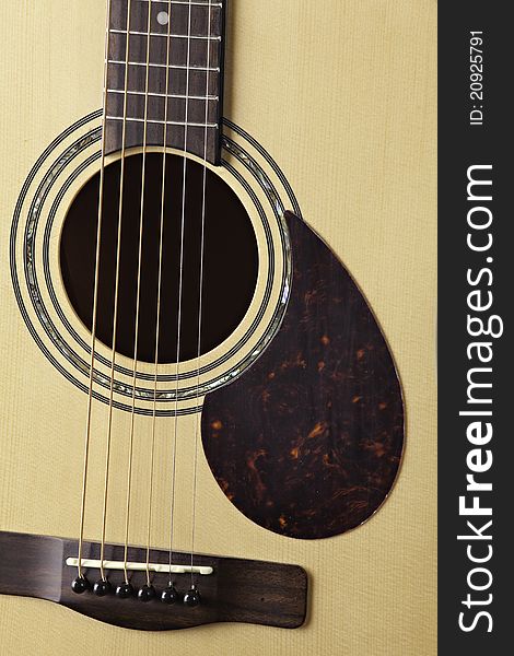 A natural finish acoustic guitar isolated close up and sharp. A natural finish acoustic guitar isolated close up and sharp.