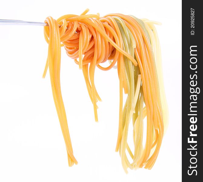 Cooked colorful Spaghetti hanging on a fork. Cooked colorful Spaghetti hanging on a fork