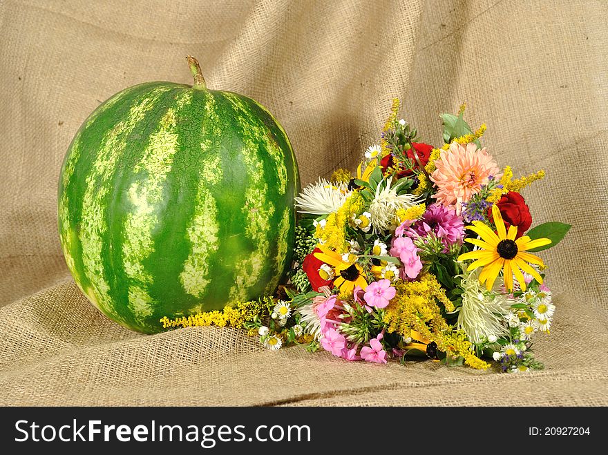 The melon and autumn flowers against rough stuff