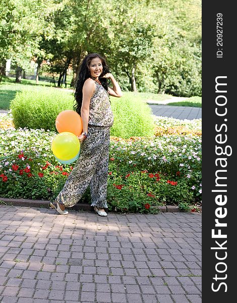 Joyful pregnant girl walking in park