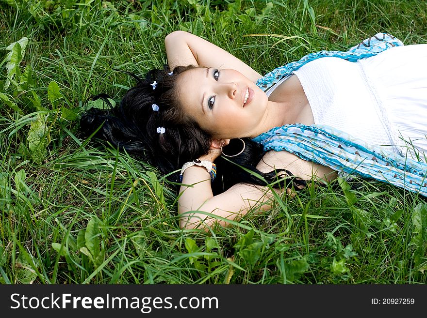 Beautiful pregnant girl lying on grass in park