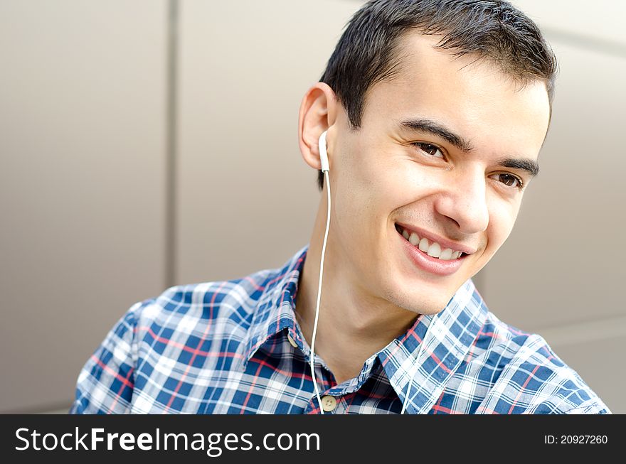 Portrait of handsome young man listening to music, smiling and looking away. Portrait of handsome young man listening to music, smiling and looking away