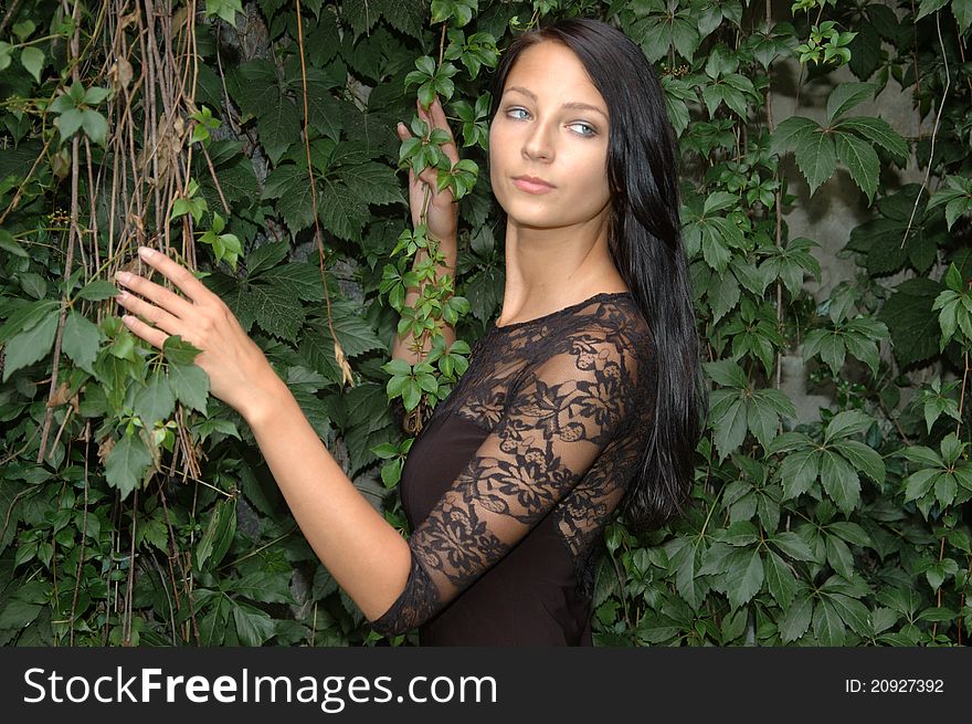 Beautiful young girl. Polish female model posing in garden, holding green branches and leaves. Beautiful young girl. Polish female model posing in garden, holding green branches and leaves.
