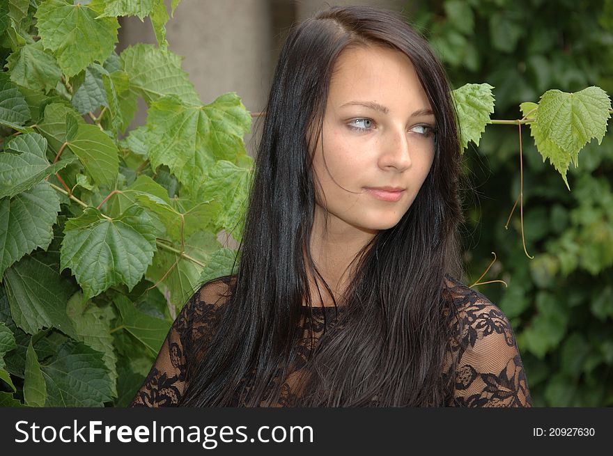 Charming female model from Poland. Young girl posing in garden with green leaves as background. Charming female model from Poland. Young girl posing in garden with green leaves as background.