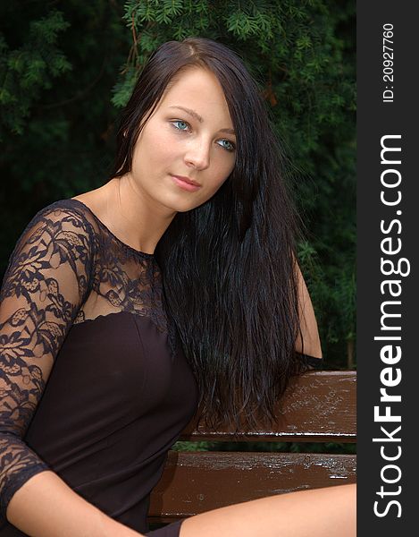 Pretty female model, wearing black skirt. Polish girl sitting at the bank in park. Pretty female model, wearing black skirt. Polish girl sitting at the bank in park.