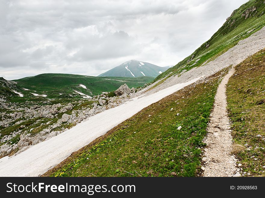 Snow and grass in the North Caucasus mountains. Russia.