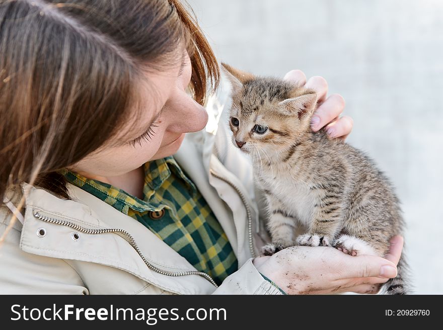 Young girl hugging a small kitten