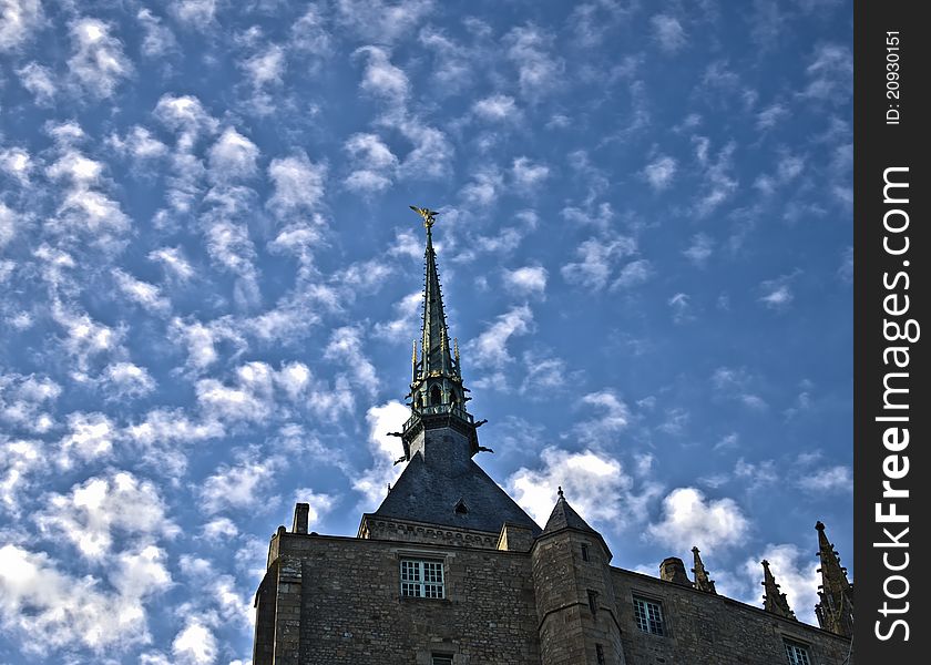 Golden statue of st. michel at mont saint michel abbey on a blue sky background. Golden statue of st. michel at mont saint michel abbey on a blue sky background