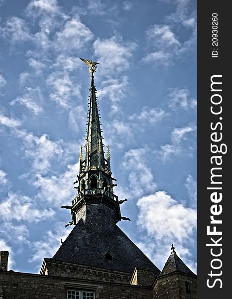 Golden statue of st. michel at mont saint michel abbey on a blue sky background. Golden statue of st. michel at mont saint michel abbey on a blue sky background