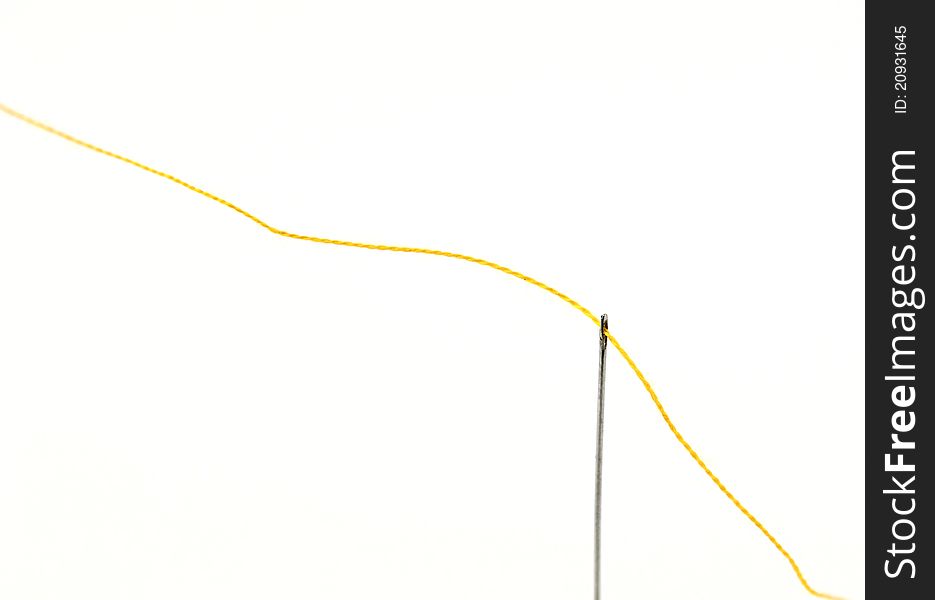 A needle with thread on white background. A needle with thread on white background.