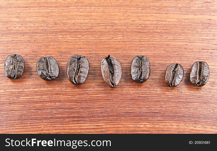 Coffee beans lined up on a wooden floor