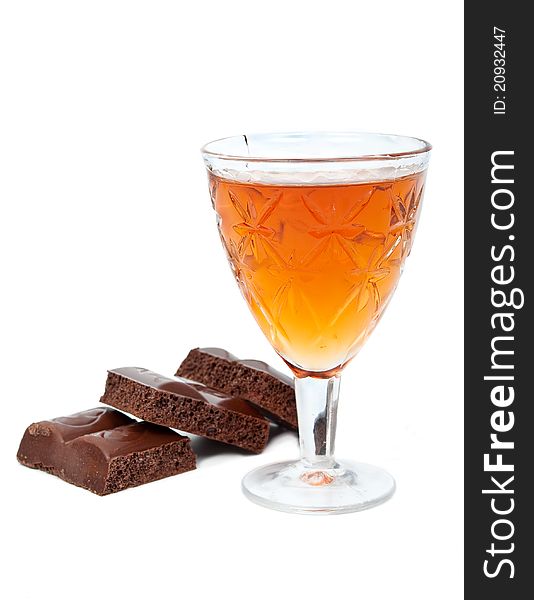 Glass of brandy with chocolate on white