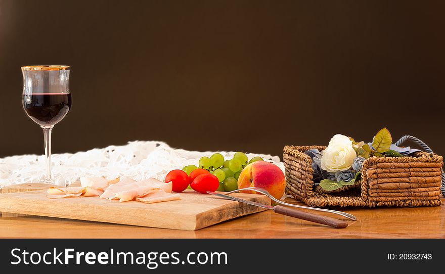 Dinner of meat, wine, fruit, tomatoes and grapes. Dinner of meat, wine, fruit, tomatoes and grapes