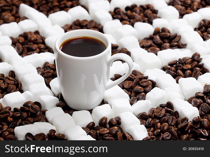 Cup of coffee with coffee beans and sugar