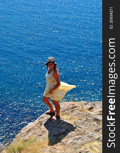 A woman standing on a rock at the sea. A woman standing on a rock at the sea