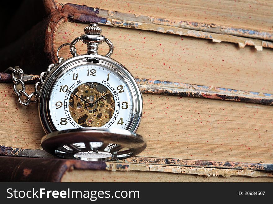 Vintage pocket watch with open lid on background with old books. Vintage pocket watch with open lid on background with old books