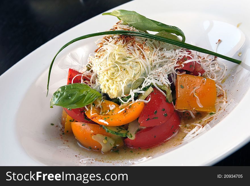 Salad with cheese and vegetables in a white plate