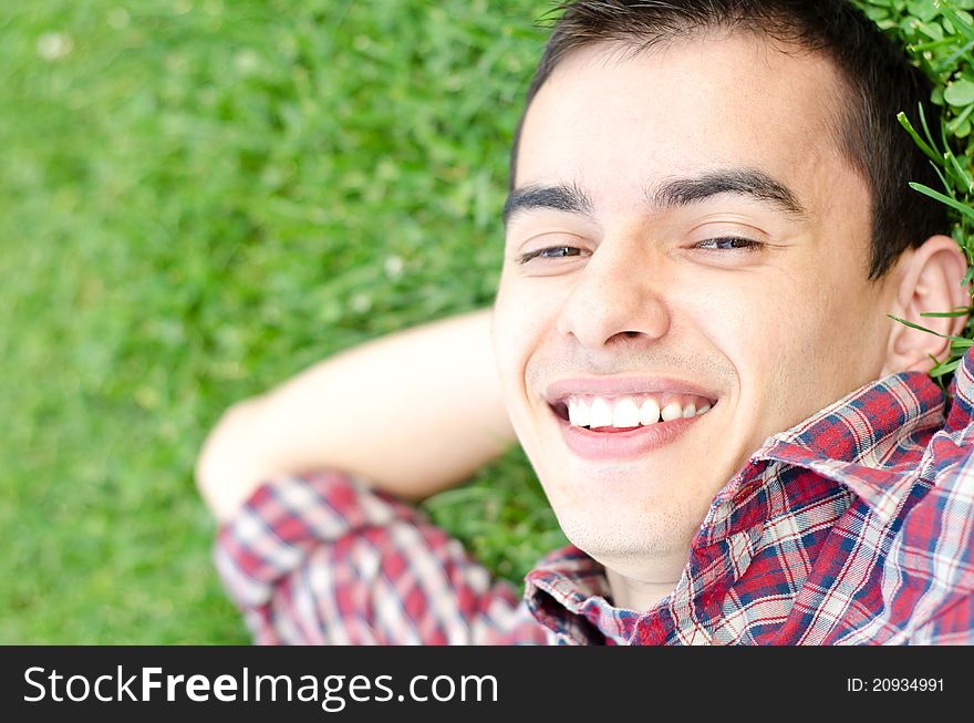 Young handsome man relaxing outdoor smiling. Young handsome man relaxing outdoor smiling