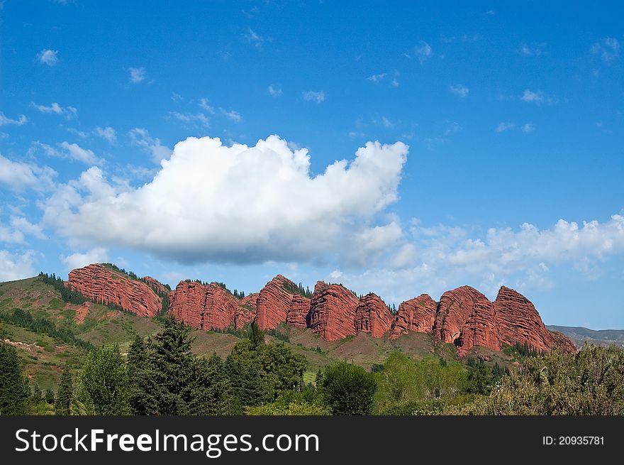 White cloud in the blue clear sky over red mountains. White cloud in the blue clear sky over red mountains