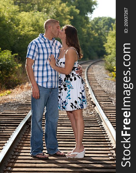 Attractive couple kissing on railroad tracks. Attractive couple kissing on railroad tracks