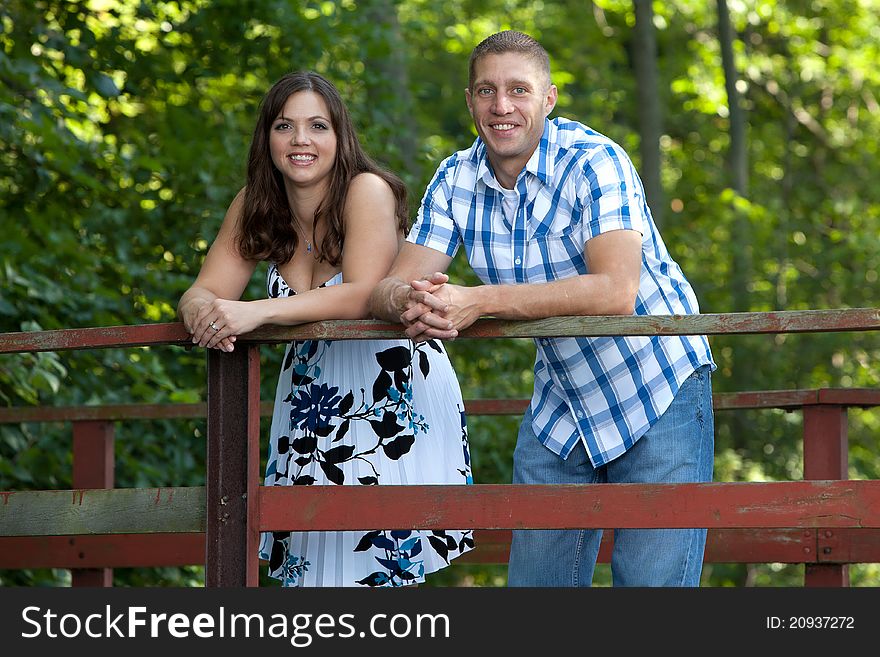 Smiling happy couple on bridge in forest