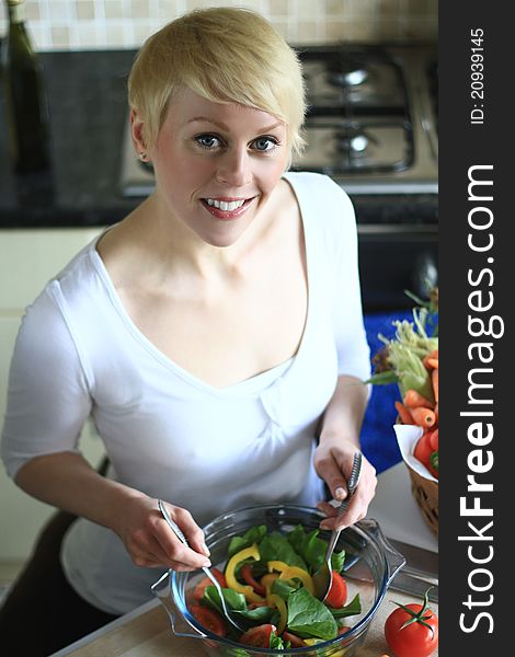 Image of a woman preparing salad in the Kitchen