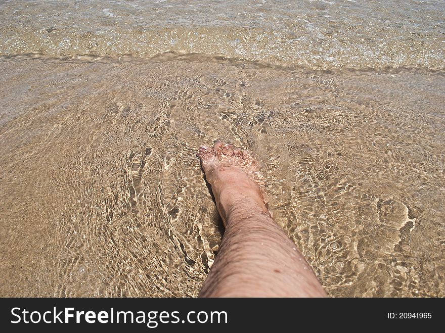 Foot in water on Rayong beach of thailand.