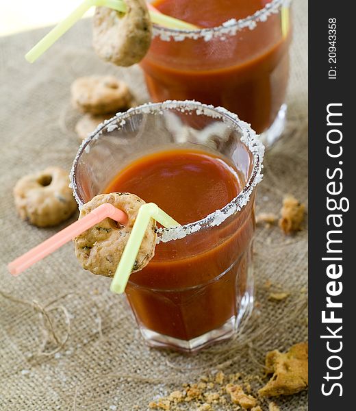 Bloody Mary or tomato juice with cookies and straw. Selective focus