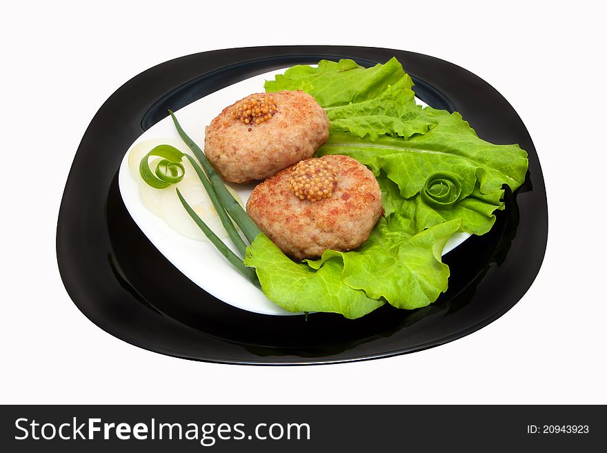 Grilled cutlets on the leaves of lettuce and onion on a plate, isolation on a white background. Grilled cutlets on the leaves of lettuce and onion on a plate, isolation on a white background