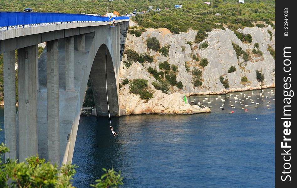 Mountainous landscape crossed by the river, with the extreme sport bungee jumping on the blue bridge, Croatia
