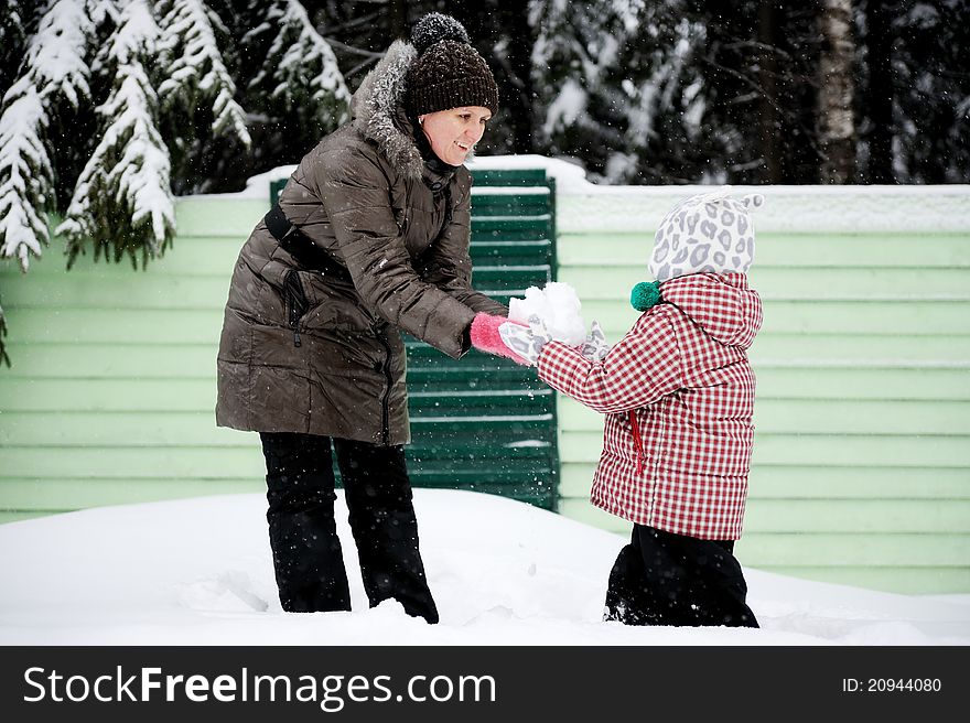 Young mother and daughter have fun in the snow
