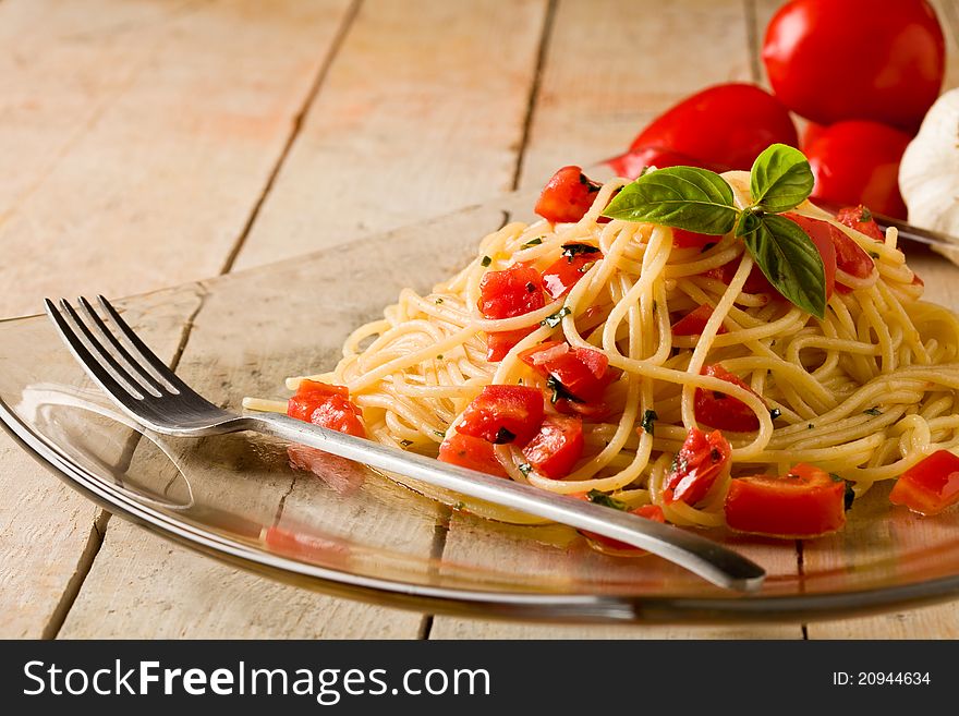 Photo of delicious spaghetti with garlic and oil sauce on wooden table