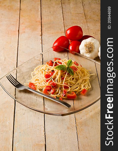 Photo of delicious spaghetti with garlic and oil sauce on wooden table