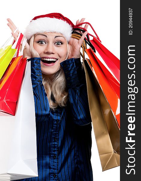 Portrait of a Christmas woman in santa hat holding a shopping bags over white background. Portrait of a Christmas woman in santa hat holding a shopping bags over white background