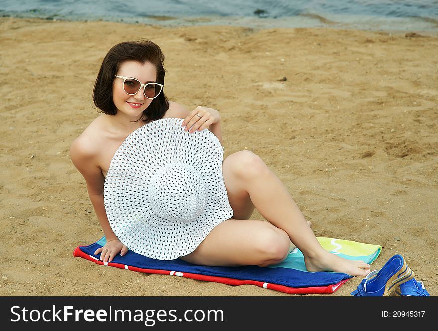 The girl on a beach in a white hat.