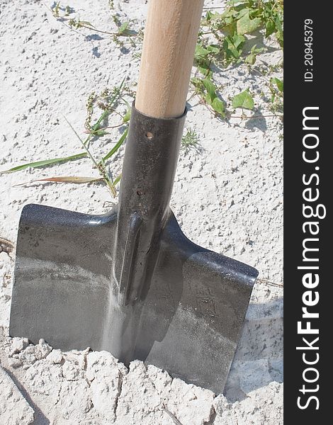 Closeup of a shovel digging into pile of building sand. Closeup of a shovel digging into pile of building sand