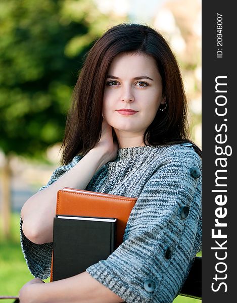 Portrait of a young female student with books at the campus