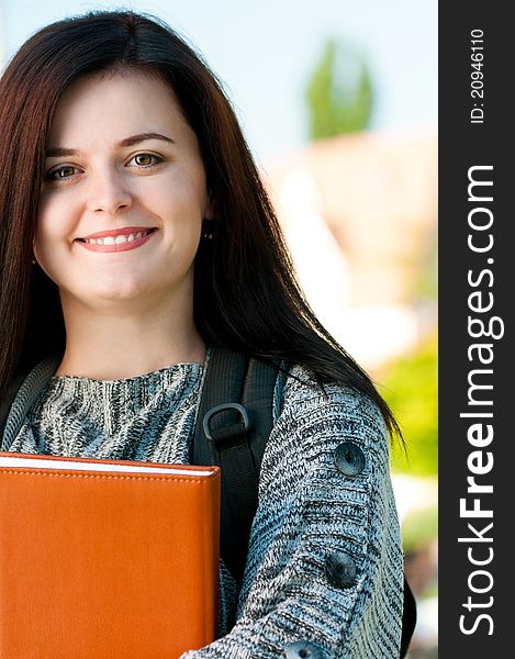 Portrait of a young female student with books at the campus